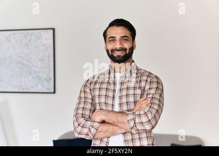 Portrait of young happy indian man looking at camera at home office. Stock Photo