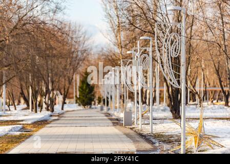 The path in Kapotnya Park. Spring in the park, the snow melts and the first grass breaks through Stock Photo