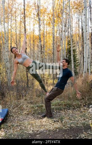 Smiling couple practicing acroyoga in forest Stock Photo
