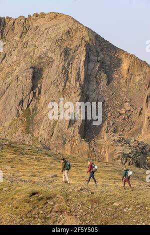 Male and female friends hiking on mountain during vacation Stock Photo