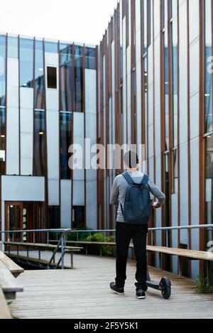 businessman commuting to work walking near electric scooter Stock Photo