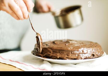Woman  cooking a chocolate cake in kitchen at home. Stock Photo