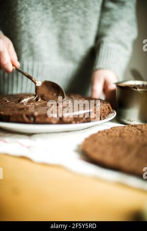 Woman  cooking a chocolate cake in kitchen at home. Stock Photo