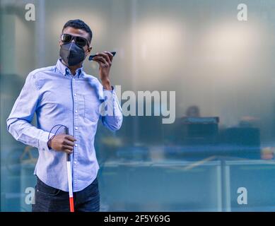 young blind african man talking on his smartphone Stock Photo