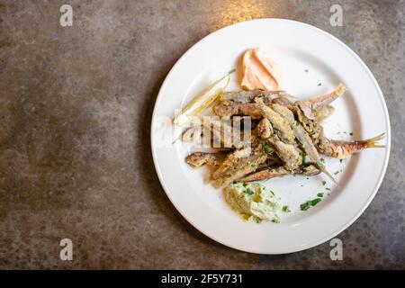 Fried capelin fish with herbs and lemon and cream sauce. Fish dish. Small fried fish, healthy food concept. Stock Photo