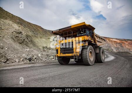 Rudny,Kazakhstan-May 14 2012:Open-pit mining iron ore in quarry. Caterpillar quarry trucks transporting ore to concentrating plant. Stock Photo