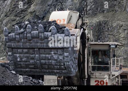 Rudny/Kazakhstan - May 14 2012:  Open-pit mining (quarry). Excavator Terex loading iron ore in  train wagon. Close-up. Stock Photo