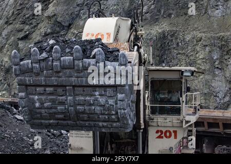 Rudny/Kazakhstan - May 14 2012:  Open-pit mining iron ore in quarry. Excavator Terex loading ore in cargo train. Close up. Stock Photo