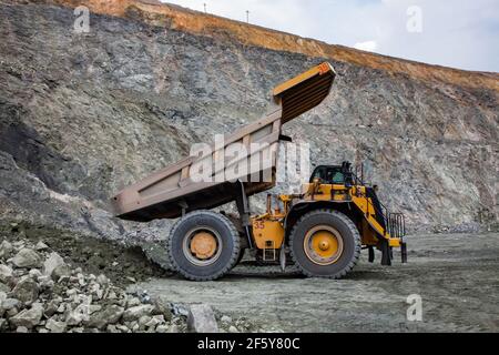 Rudny/Kazakhstan - May 14 2012:  Open-pit mining iron ore in quarry. Caterpillar quarry truck dumping car. Stock Photo