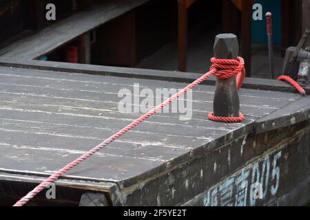 Rope from a small boat tied to a mooring bollard. Stock Photo