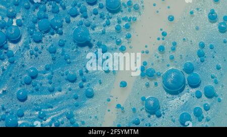 Top view movement of blue oil ink drops bubbles, multicolored artistic paint surface background Stock Photo