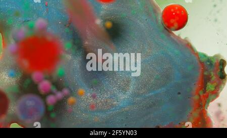 Top view movement of dark oil ink drops bubbles, multicolored artistic paint surface background Stock Photo