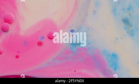 Top view movement of pink oil ink drops bubbles, multicolored artistic paint surface background Stock Photo