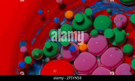 Top view movement of green oil ink drops bubbles, multicolored artistic paint surface background Stock Photo
