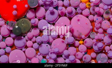 Top view movement of purple oil ink drops bubbles, multicolored artistic paint surface background Stock Photo