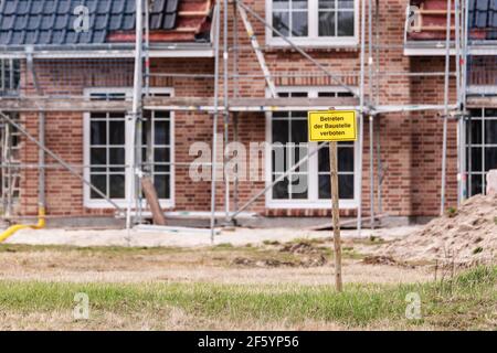 In front of an almost finished family house is a sign with the German inscription Construction site No trespassing Stock Photo