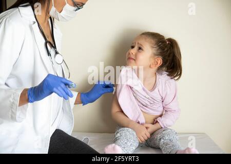 chubby little girl in pediatric examination by her doctor. vaccinated by her doctor. Selective Focus. covid vaccine baby Stock Photo