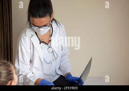 chubby little girl in pediatric examination by her doctor. They are looking x-ray film. copy space, space for text. Selective Focus Stock Photo