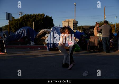 Tijuana, Mexico. 27th Mar, 2021. Two children hug. Migrants from Central America are stuck living in tents on the street in Tijuana, Mexico on the border while they wait for President Joe Biden to open the American border. Credit: Allison Dinner/ZUMA Wire/Alamy Live News Stock Photo