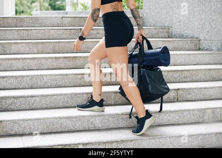 Cropped image of fit young woman with gym bag walking up the stairs Stock Photo