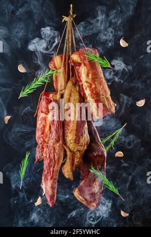 Composition of ssortment of air dried and smoked lamb and beef meat on hanger Stock Photo