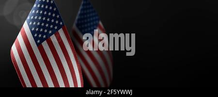 Small national flags of the United States on a dark background Stock Photo