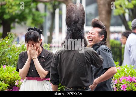 Japanese rockabillies with quiffs sharing a joke in Yoyogi Park, Harajuku, Tokyo, Japan Stock Photo