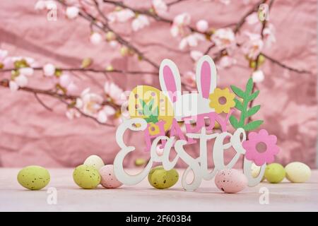 Easter decoration with Easter eggs, bunny and cherry blossoms on a pink background. Happy Easter Stock Photo