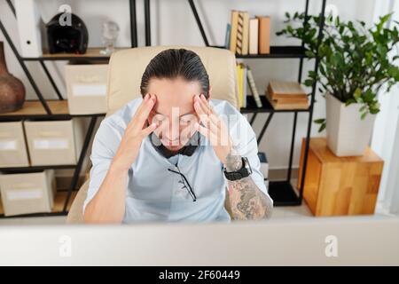 Entrepreneur suffering from headache after working on big project all day long without breaks Stock Photo