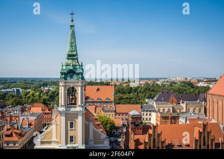 Torun, Poland - August 2020 : Panoramic view of The Church of the Holy Spirit surrounded by buildings under the sunlight and a blue sky in Torun Old t Stock Photo