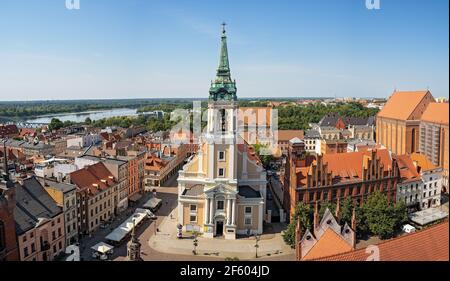 Torun, Poland - August 2020 : Panoramic view of The Church of the Holy Spirit surrounded by buildings under the sunlight and a blue sky in Torun Old t Stock Photo