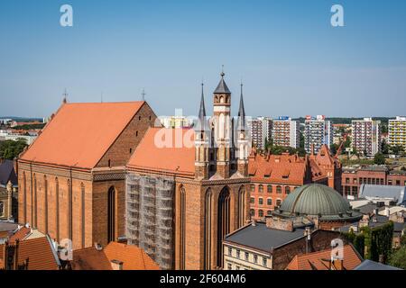 Torun, Poland - August 2020 : The Church of the NMP  Najswietszej Maryi Panny  surrounded by buildings under the sunlight and a blue sky in Torun Old Stock Photo