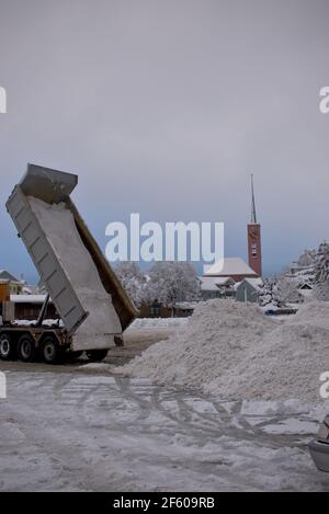 Truck is unloading a lot of snow on a heap in Buchs in Switzerland 15.1.2021 Stock Photo