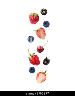 Isolated fresh berries float in the air. Falling blackberry, blueberry, cherry and strawberry fruits isolated on white background with clipping path. Stock Photo