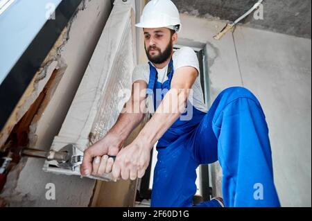 Male worker installing radiator in the apartment. Stock Photo