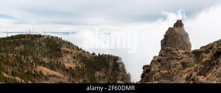 Panoramic view of 'Pico de las Nieves', near Tejeda surrounded by clouds on the island of Gran Canaria and communication towers in background. Mountai Stock Photo