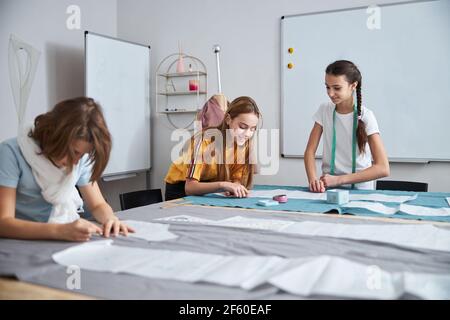 Joyful cute girls working in sewing workshop Stock Photo