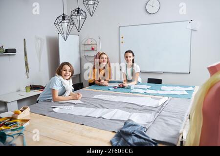 Joyful adorable girls working in sewing workshop Stock Photo