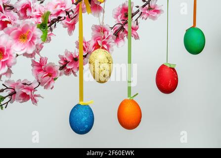 Easter background composition with hanging eggs on a branch, on a white background Stock Photo