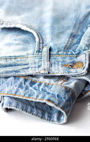 Blue jeans on a white background. The texture of the cotton fabric. Close up. Vertical crop. Stock Photo