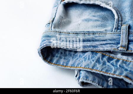 Blue jeans on a white background. The texture of the cotton fabric. Close up. Copy space. Stock Photo