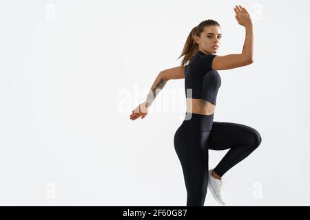 Smiling healthy sportswoman turn head behind. Rear view of fitness girl  back in sportsbra, looking happy at camera, white background Stock Photo -  Alamy