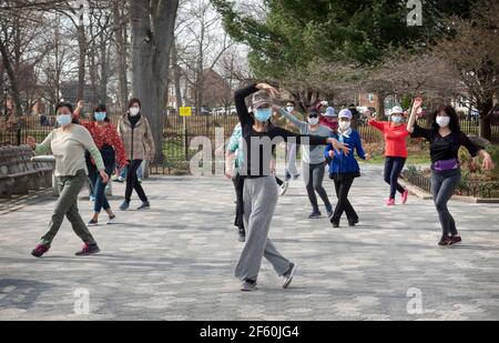 A slender graceful Chinese American instructor teaches a dance exercise class in a park in Queens, New York City. Stock Photo