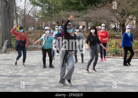 A slender graceful Chinese American instructor teaches a dance exercise class in a park in Queens, New York City. Stock Photo