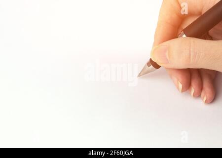 Cropped Hand Writing On White Background. Person's Hand Marking On Checklist Stock Photo