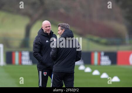 Hensol, Wales, UK. 29th Mar, 2021. Interim head coach Robert Page (left) speaks with assistant Albert Stuivenberg during Wales national football team training at Vale Resort ahead of the World Cup qualification match against Czech Republic. Credit: Mark Hawkins/Alamy Live News Stock Photo