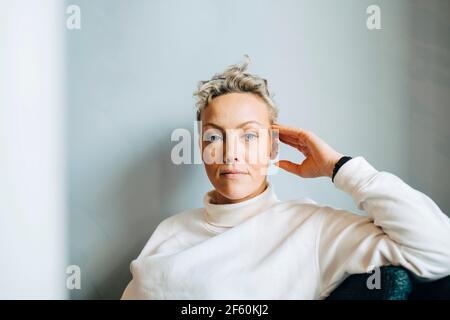 Portrait of confident businesswoman against wall in office Stock Photo