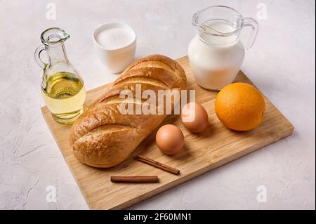 Ingredients for cooking homemade traditional Spanish torrijas or French toasts on the cutting board. Popular dessert for Christmas, Easter or Pascua Stock Photo