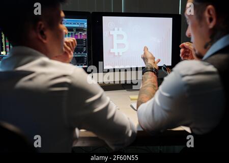 Doubtful financial brokers watching for bitcoin trading opportunities Stock Photo