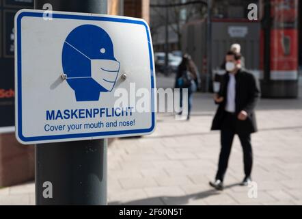 Hamburg, Germany. 29th Mar, 2021. A man walks past a sign in the city centre with the inscription 'Maskenpflicht'. A new Corona ordinance has been in effect in Hamburg since midnight. With the order, the Senate extends the lockdown until April 18, 2021. Credit: Daniel Reinhardt/dpa/Alamy Live News Stock Photo